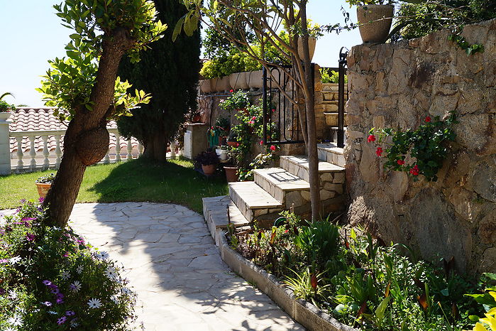 Jolie maison avec jardin fleuri en location á Cala Canyelles.