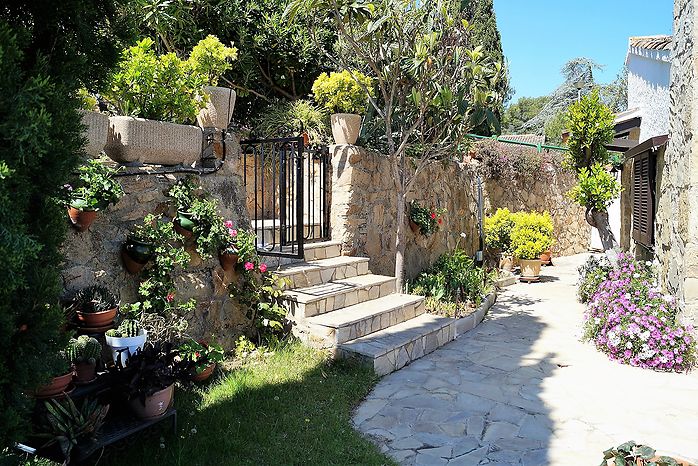 Jolie maison avec jardin fleuri en location á Cala Canyelles.